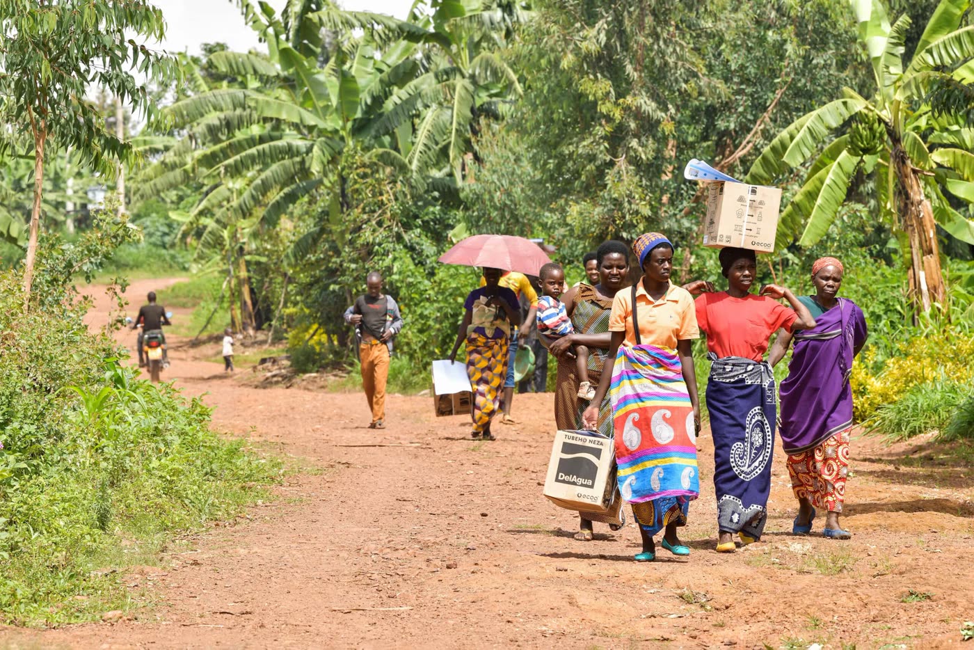 Families carrying new cookstoves home after distribution
